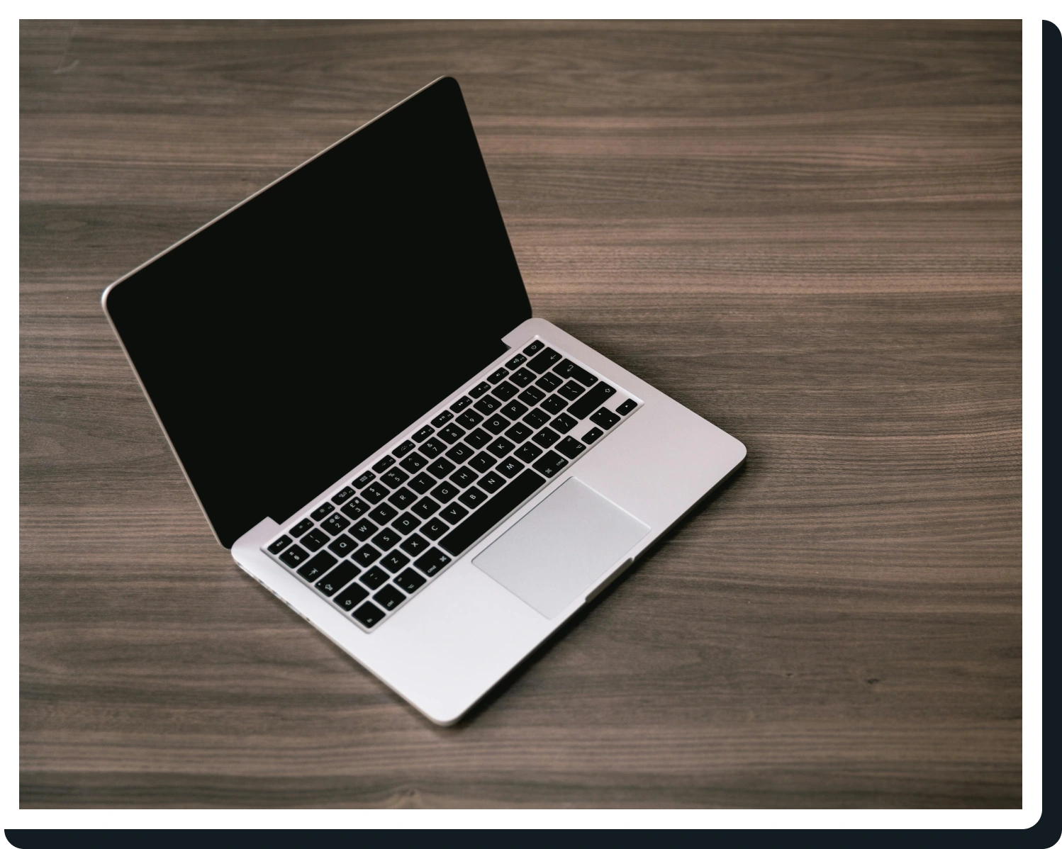 A laptop sitting on top of a wooden table.