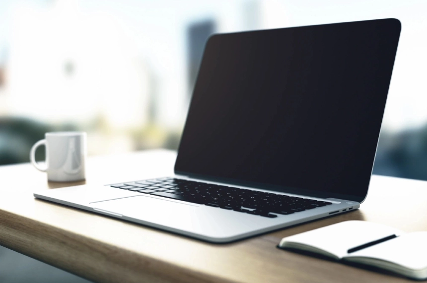 A laptop sitting on top of a wooden desk.