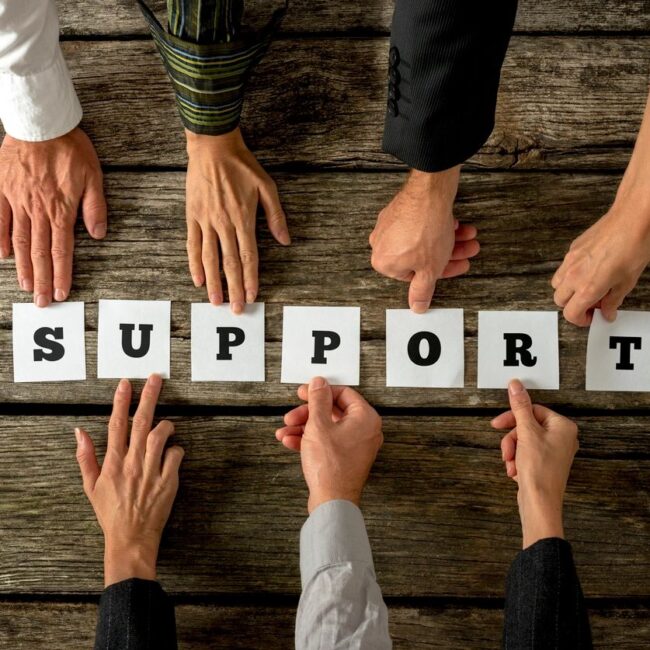 Six diverse hands lifting or forming the word "Support" together