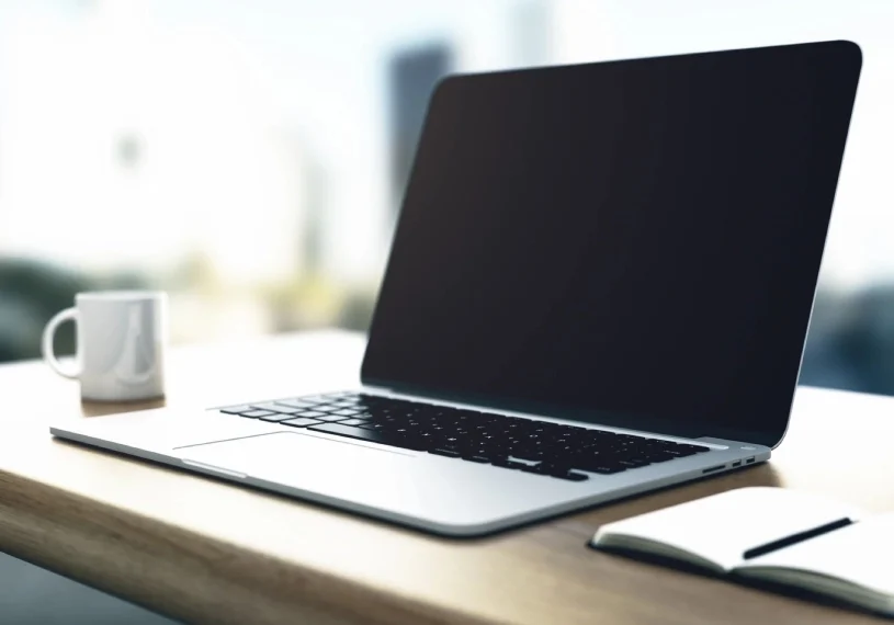 A laptop sitting on top of a wooden desk.